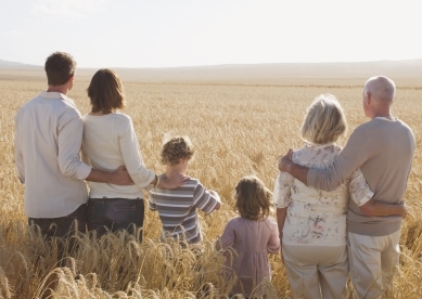 Family hugging in remote wheat field